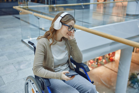 A young woman enjoying music while relaxing in her wheelchair at a busy mall