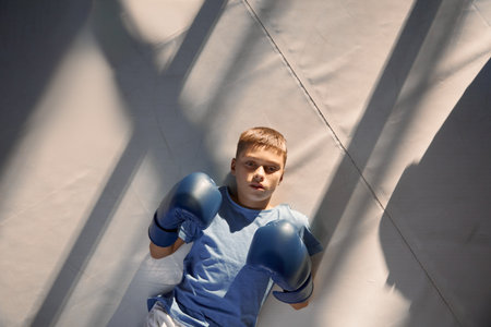 High above view on teenage boy lying on boxing ring floorの写真素材