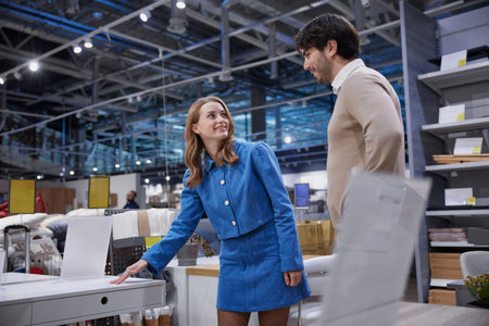 Loving couple is exploring and shopping for stylish office furniture in a modern retail storeの写真素材