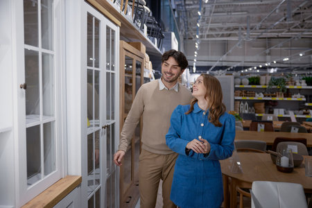 A young couple joyfully shopping for stylish furniture in a modern, vibrant store settingの写真素材