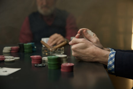 An intense poker game highlighted by chips, cards and players in a mysterious atmosphereの写真素材