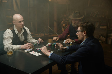 Three gentlemen playing poker game in a vintage old libraryの写真素材