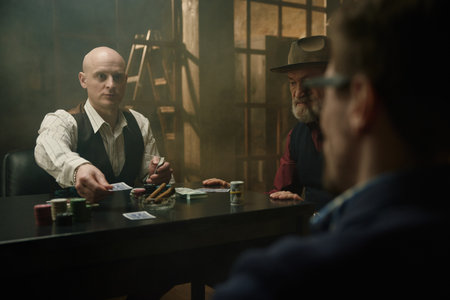 Intense poker and card game in a smoky room between male companyの写真素材
