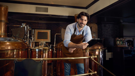 A man wearing an apron is studying a clipboard in a brewery setting