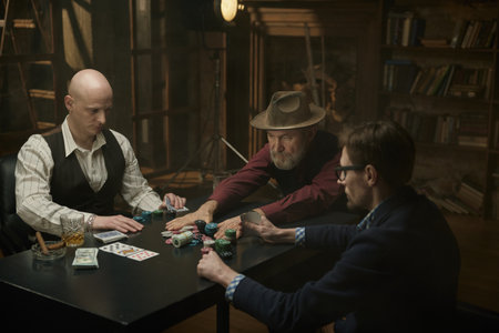 Male company enjoying a table game in a smoky library
