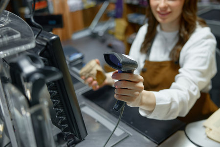 A woman is actively using a barcode scanner in a retail store