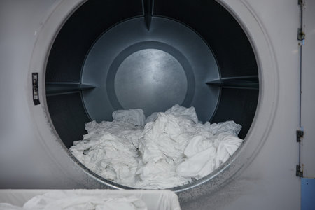 The interior of a washing machine completely filled with white clothesの写真素材