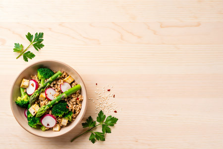 Bowl of healthy buckwheat salad with radish, asparagus and flax seeds on wooden backgroundの素材