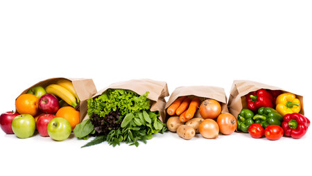 Paper bag full of fresh vegetables and fruits isolated on white background.の素材