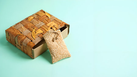 Wicker box with a straw bag on a turquoise backgroundの素材