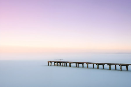 Wooden pier on the sea at sunrise, fog in the backgroundの素材