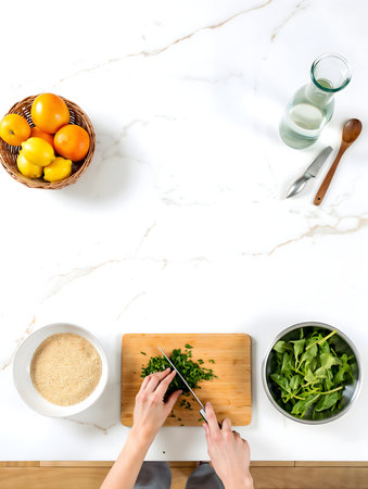 Top view of woman's hands cutting fresh arugula leaves in a bowl on white marble tableの素材