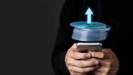 Close up of a man holding mobile smart phone with blue arrow icon on itの素材