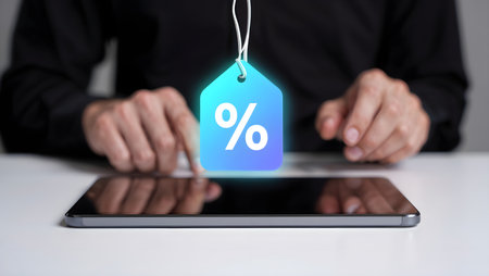 Hands holding tablet with percentage sign on the screen. Online shopping concept.の素材