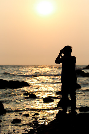 The photographer is taking a photo in sunset view silhouetted の写真素材