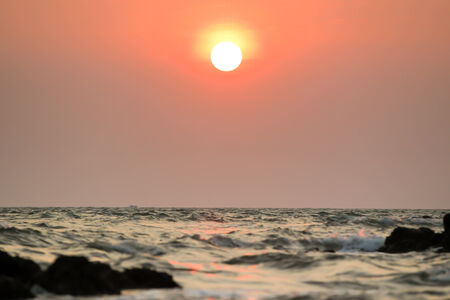 Sunset and sea wave silhouetted background の写真素材