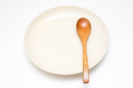Wooden spoon and plate in white background.の写真素材