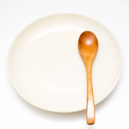 Wooden spoon and plate in white background.の写真素材