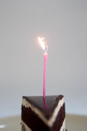 Chocolate cake with burning birthday candle.の写真素材