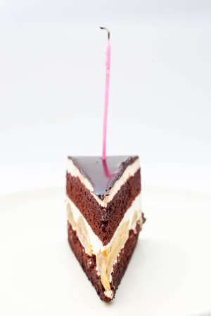Chocolate cake with burning birthday candle.の写真素材