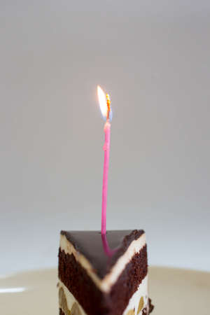 Chocolate cake with burning birthday candle.の写真素材