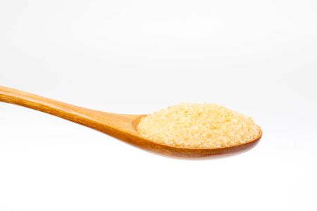 Brown sugar on wooden spoon isolated.の写真素材