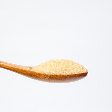 Brown sugar on wooden spoon isolated.の写真素材