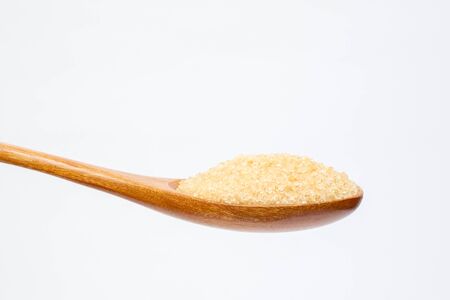 Brown sugar on wooden spoon isolated.の写真素材
