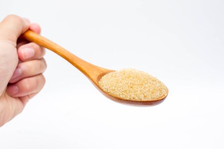 Brown sugar on wooden spoon isolated.の写真素材
