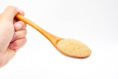 Brown sugar on wooden spoon isolated.の写真素材