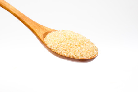 Brown sugar on wooden spoon isolated.の写真素材