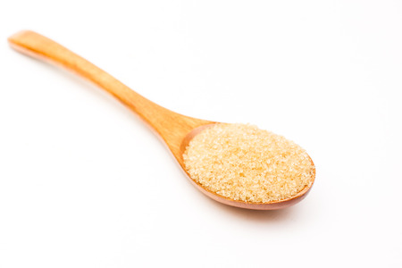 Brown sugar on wooden spoon isolated.の写真素材