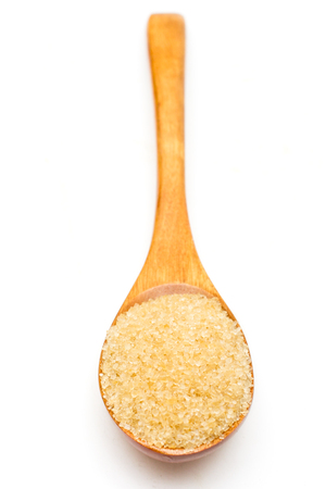 Brown sugar on wooden spoon isolated.の写真素材