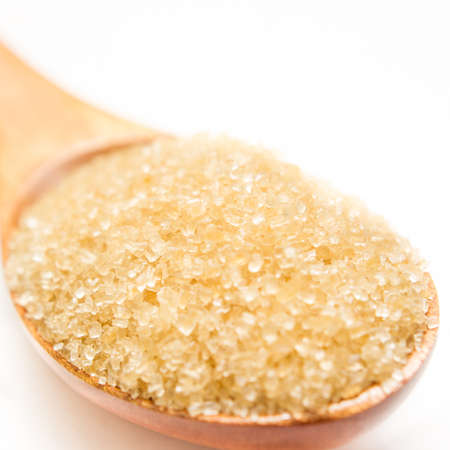Brown sugar on wooden spoon isolated.の写真素材
