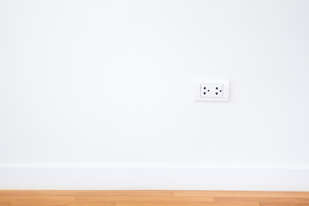 Modern female plug in white wall background.の写真素材