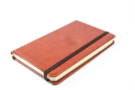 Small brown notebook isolated in white background.の写真素材