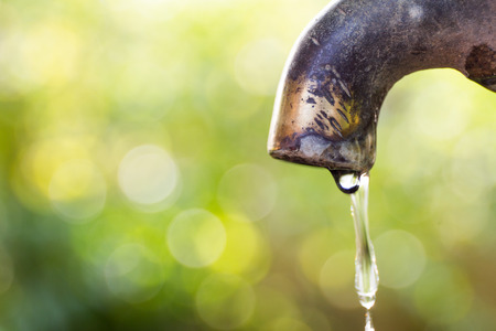 Brass water tap in nature background.の写真素材