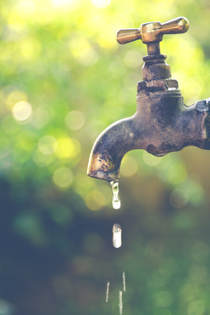 Brass water tap in nature background. (Processed in vintage colour tone)の写真素材