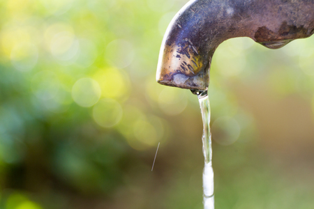 Brass water tap in nature background.の写真素材