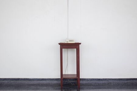 Old telephone on the wooden desk close up.の写真素材