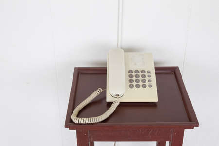 Old telephone on the wooden desk close up.の写真素材