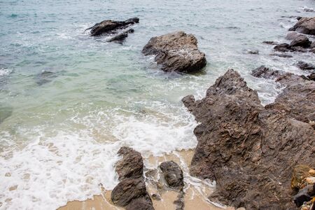 Small wave and rock on the beach.の写真素材
