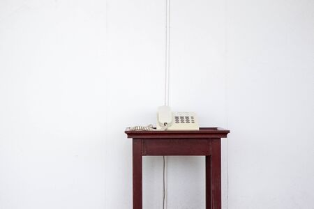 Old telephone on the wooden table close up.の写真素材