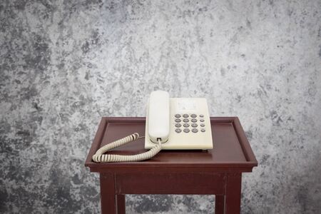 Old telephone on the wooden in concrete roomの写真素材