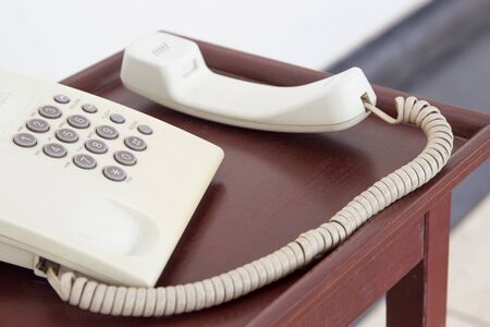 Old telephone on the wooden table close up.の写真素材