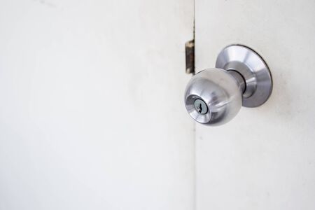 Doorknob in wooden door close up.の写真素材