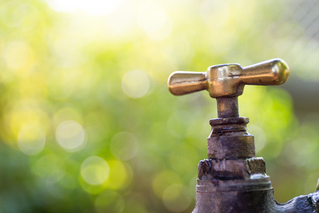 Brass water tap in nature background.の写真素材