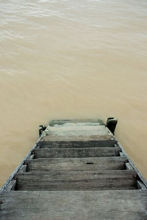 Old wooden stair way to lake close up.の写真素材