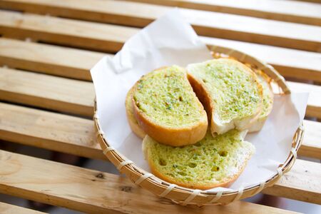 Garlic grilled bread in wooden basket close up.の写真素材