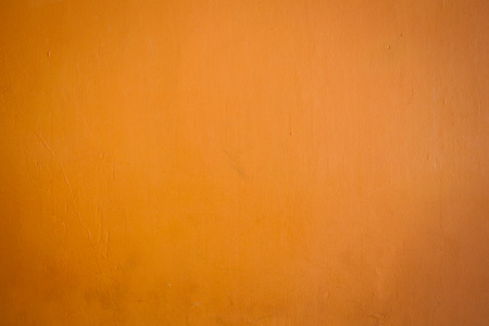 Aged concrete wall painted in orange and yellow colour.の写真素材